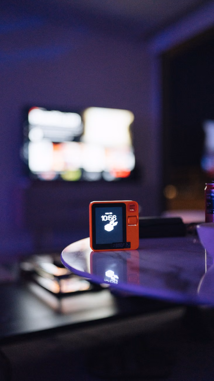 A digital device on a glass table in a neon-lit modern indoor setting.